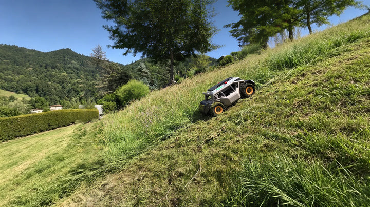 Mowrator slope mower cutting tall grass on a steep, scenic hillside