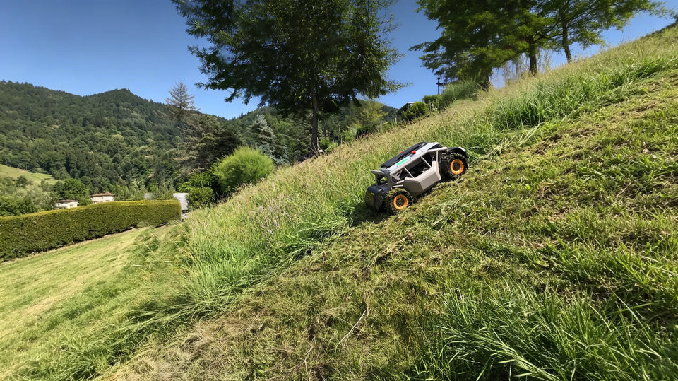 Mowrator slope mower cutting tall grass on a steep, scenic hillside