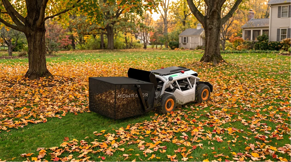 Mowrator robotic leaf collector with orange wheels gathering autumn leaves into black mesh bag on suburban lawn