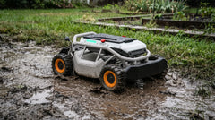 Mud-covered Mowrator remote control mower sitting on waterlogged ground after a storm
